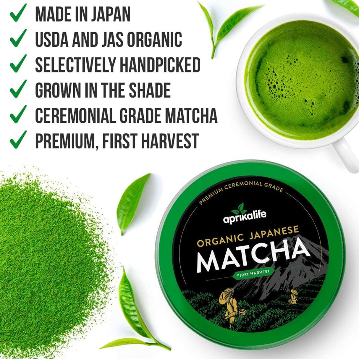 A container of Black Matcha Tea from the gift set sits next to a cup of prepared matcha, surrounded by fresh green leaves. A bamboo whisk is nearby, suggesting the traditional preparation method.