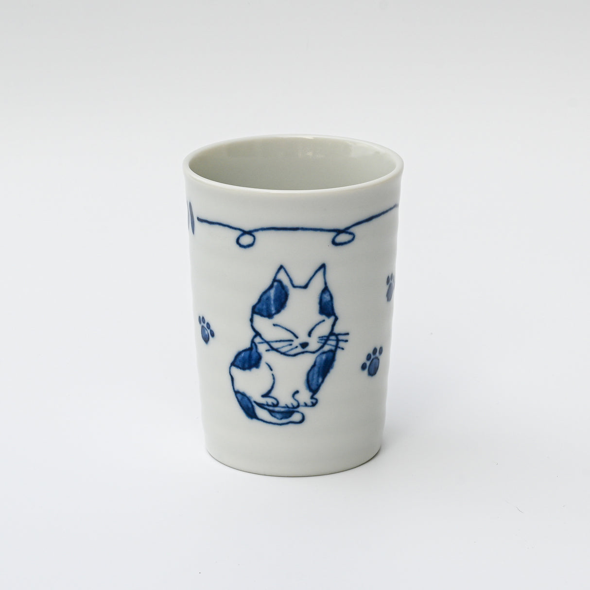 The Adorable Cat 3 Tea Cup, a 180ml Mino-ware from Gifu Prefecture, showcases charming blue cat drawings and paw prints on a crisp white ceramic background, ideal for any cat tea cup collection.