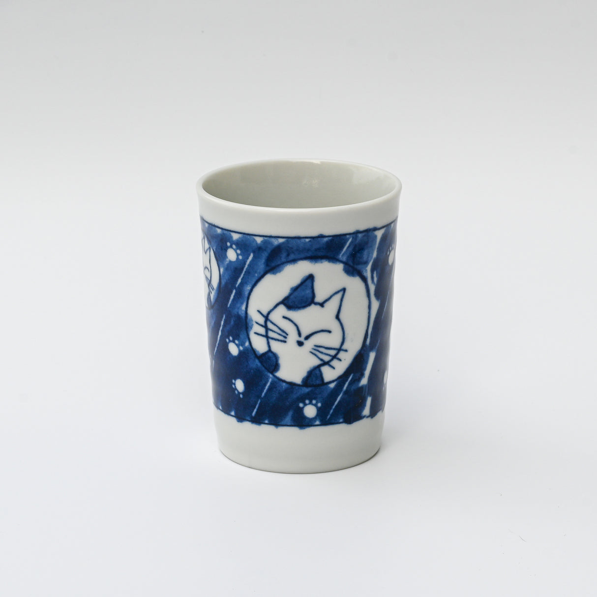 The Adorable Cat 4 Tea Cup features blue cat face illustrations and circular patterns on white Mino-ware, inspired by traditional Gifu Prefecture designs. Holds 180ml (6oz.) and comes in classic blue & white.