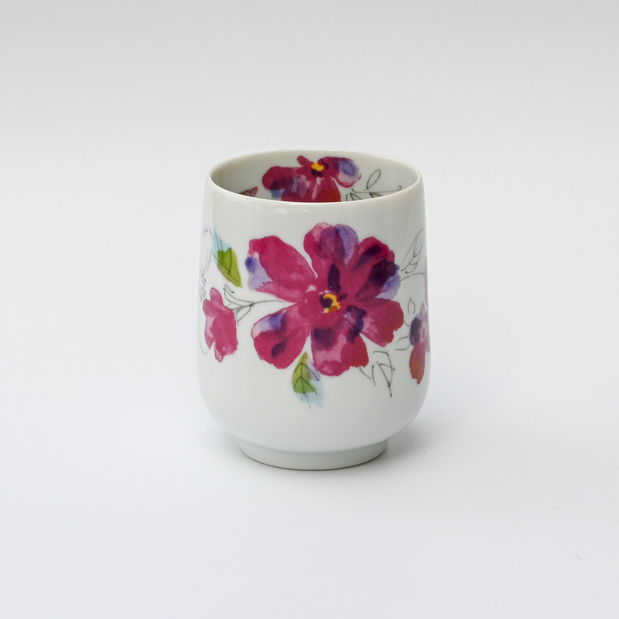 The Pink Flower Waisted Tea Cup is a white ceramic masterpiece of Minoyaki pottery featuring a pink and red floral design on a plain background.