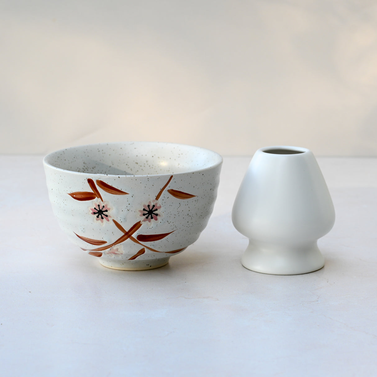 A Bamboo Matcha Bowl and a bamboo whisk holder set grace the light surface, hinting at a serene tea ritual.