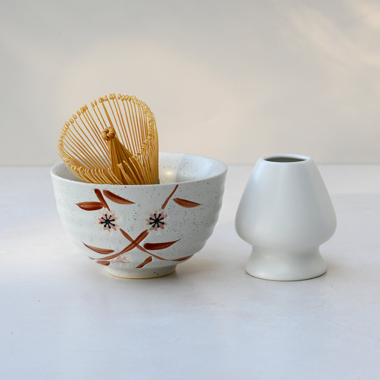 The Bamboo Matcha Bowl, Bamboo Matcha Whisk, and Whisk Holder Set is elegantly displayed as a complete matcha tea set on a light surface.