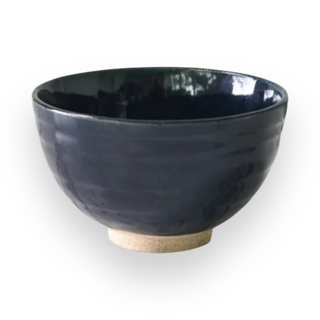 The Dark Navy Blue Ceramic Matcha Bowl, with its glossy finish and light-textured base, sits elegantly on a black background, making it perfect for any matcha tea starter set.