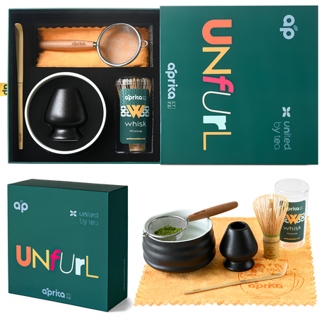 Explore the "Ceremonial Matcha Starter Kit - Black" by Aprika, which includes a ceramic bowl, bamboo whisk, sifter, spoon, and premium matcha elegantly presented in a dark box.