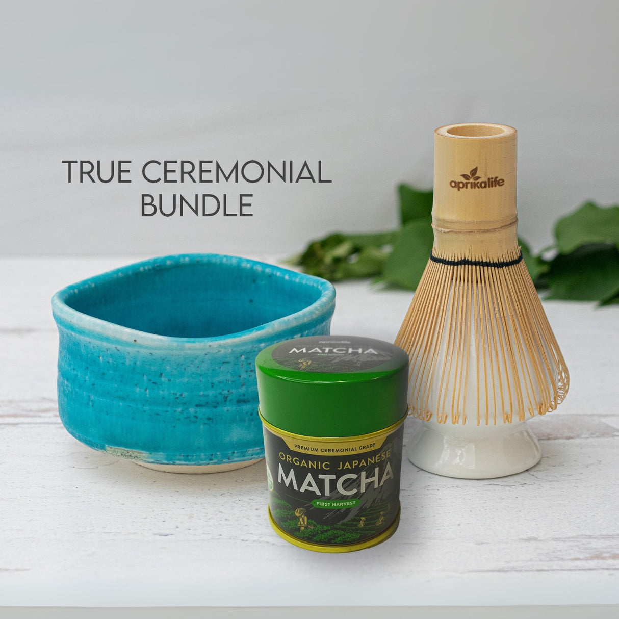 The Ceremonial Matcha Set includes the Iguchi Blue Ceramic Matcha Bowl, a bamboo whisk, and an organic matcha container, all elegantly showcased against a light backdrop.