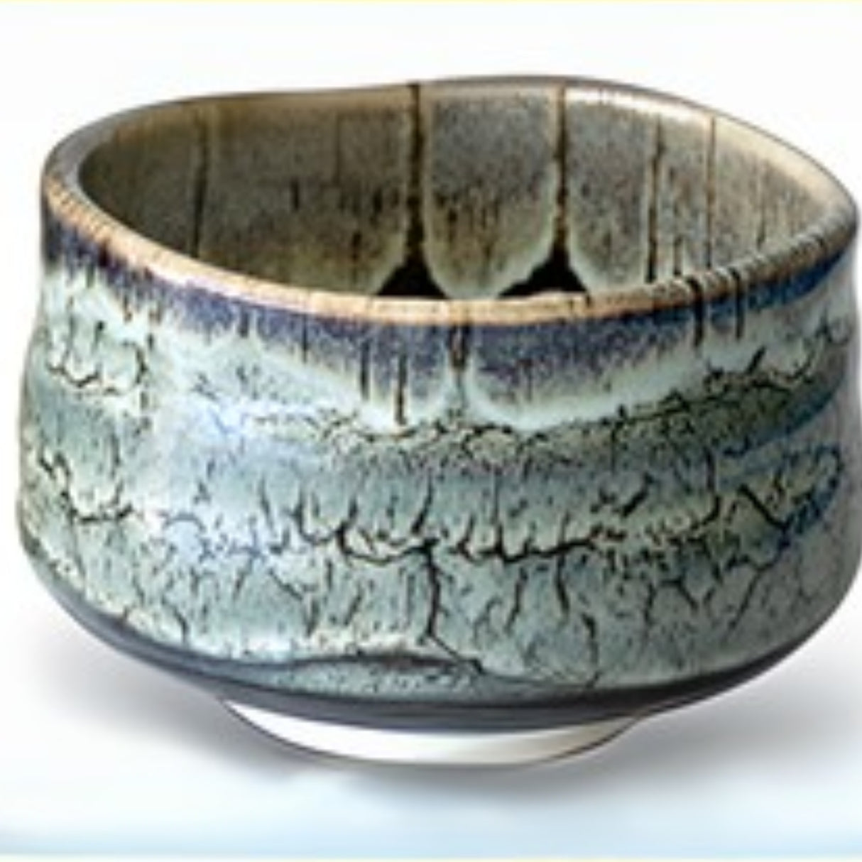 A green Iguchi Tenmoku Glaze Matcha Bowl with a textured, wavy rim rests elegantly on a white background.