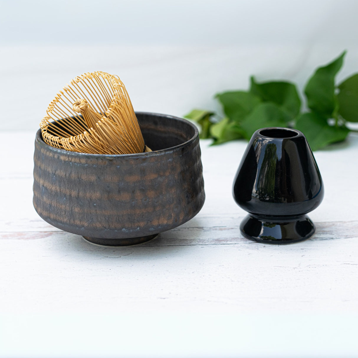 The Kaneni Gold Crystal Ceramic Matcha Bowl, paired with a bamboo whisk and black holder, makes an elegant matcha accessory set for any collection.