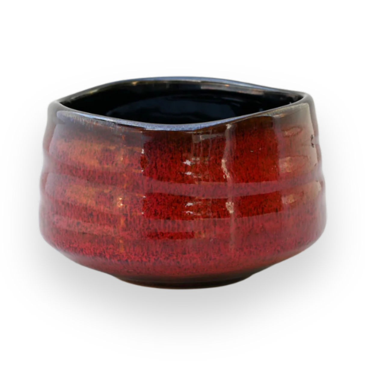 The Red Matcha Bowl features a red glaze and a rounded, slightly uneven shape, evoking the essence of traditional Minoyaki Pottery, set against a black background.