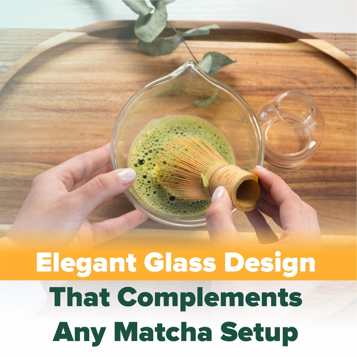 Hands whisking matcha in a glass bowl on a wooden tray, featuring the Clear Glass Matcha Whisk Holder and Bamboo Whisk Set for an elevated tea experience.