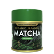 Green tin of Organic Japanese Ceremonial Grade Matcha Green Tea Powder featuring mountain and field illustrations on the label.