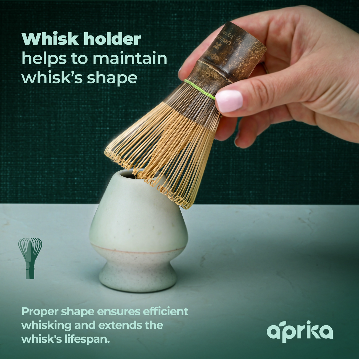 A hand gently places a Dark Matcha Bamboo Whisk (100 Prongs) on a ceramic stand, emphasizing the importance of maintaining its shape for ceremonial Matcha tea rituals. More than just a tool, it makes a unique gift for those who value tradition and elegance.