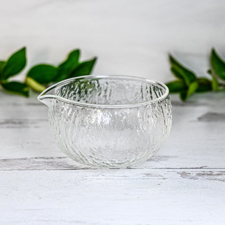 Textured Spouted Glass Matcha Bowl Pattern 2 with bamboo matcha whisk and whisk holder set—a stylish set featured on a light surface with green leaves in the background, perfect for elevating your matcha experience.