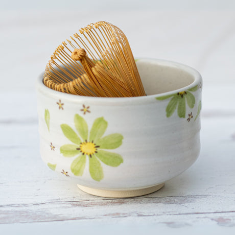 The Green Flowers Ceramic Matcha Bowl, Bamboo Matcha Whisk and Whisk Holder Set features a floral-patterned bowl with matching whisk and holder—ideal as a matcha starter kit or for enjoying traditional tea ceremonies.