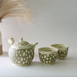 A Japanese Kyusu Set with a 370ml teapot featuring filters and two matching cups sits on a white surface, a vase of pampas grass completes the serene setting, perfect for brewing your favorite green tea.