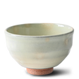 The Kohiki White Clay Matcha Bowl with a textured base, part of a set including a bamboo whisk, whisk holder, and organic Japanese matcha, is displayed against a white background.